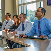 Members of the neurological cancer disease management team meet weekly to discuss patient cases.